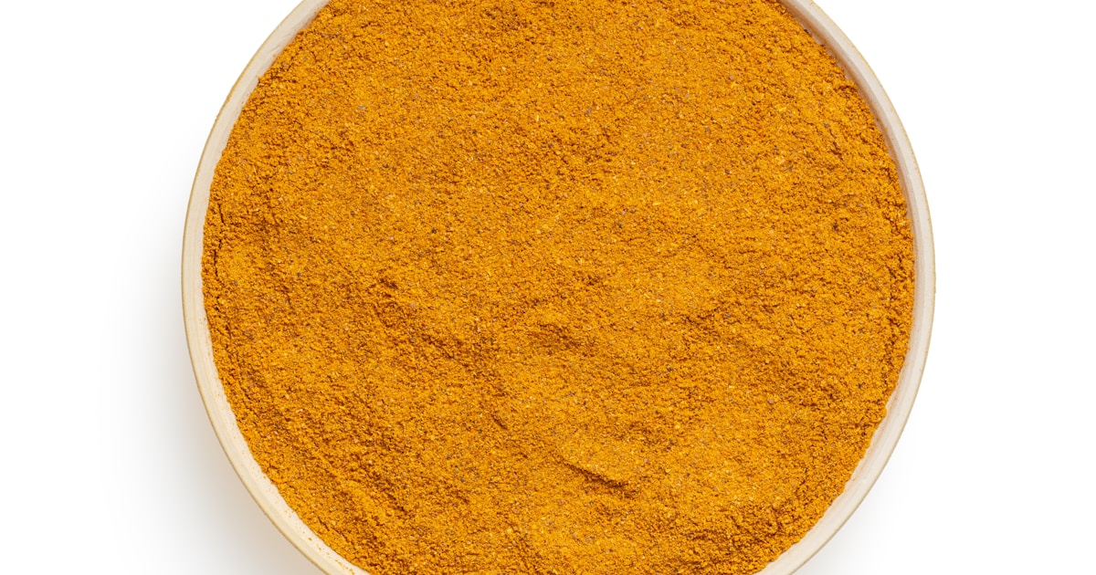 Cúrcuma en polvo sobre superficie blanca - suplementos de curcumina